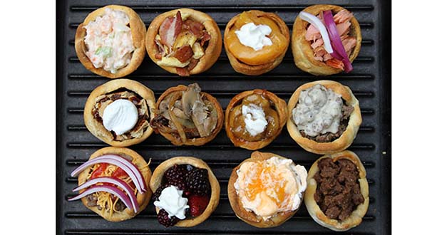 Display of 12 different campfire biscuit cup fillings on cast iron Dutch Oven lid.