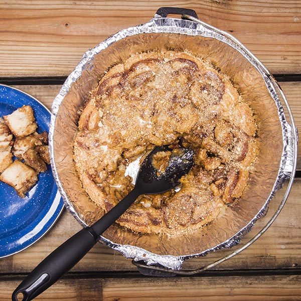 Can't decide between cinnamon rolls or caramel rolls for camping breakfast? With this super easy Dutch Oven Gooey Caramel Cinnamon roll recipe, you can have both!