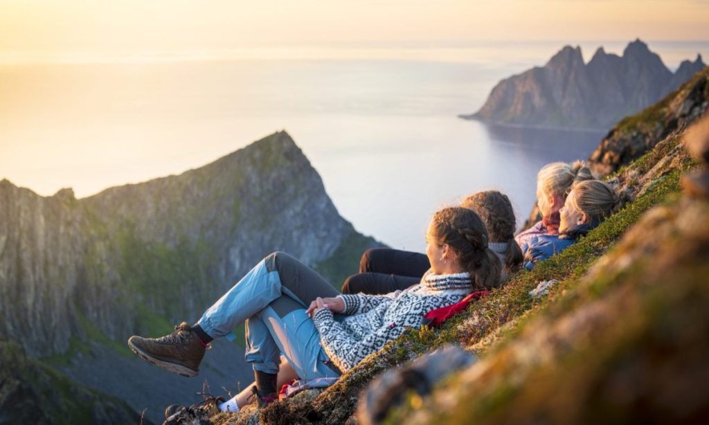 Cheerful young women watching sunset, Senja island, Norway Cheerful young women watching sunset, Senja island, Norway