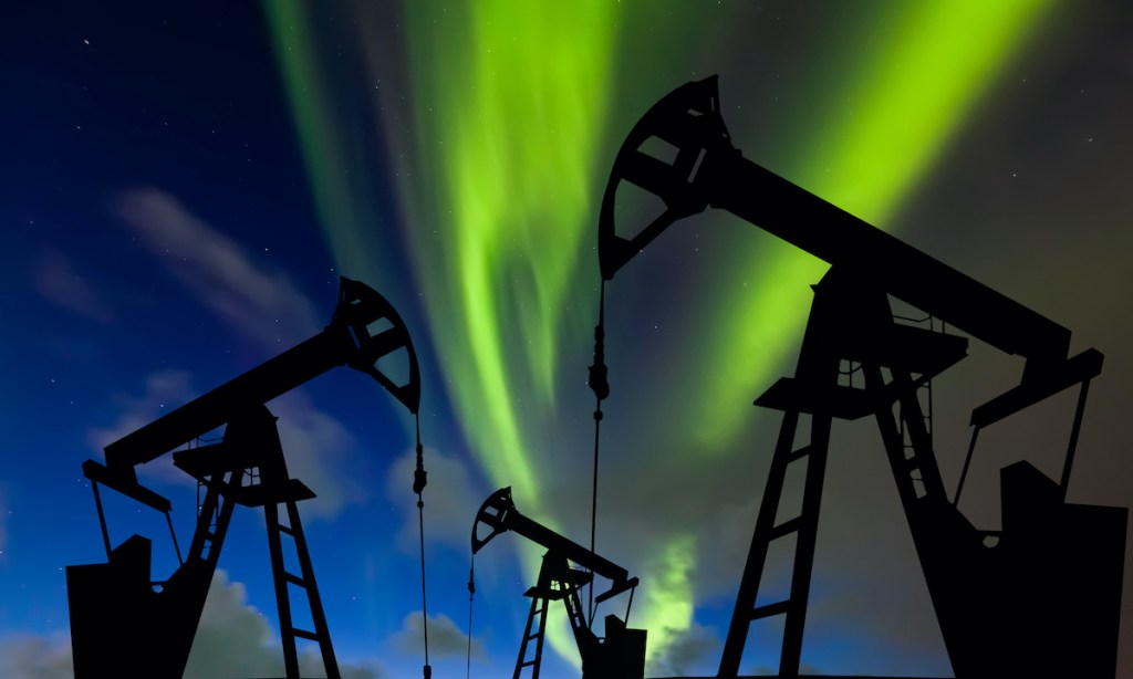 Oil pump on the northern lights background. Oil production in the far north