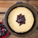 Dutch oven cheese cake is delicious and surprisingly easy to make when you use a premade crust in an aluminum foil pie tin.