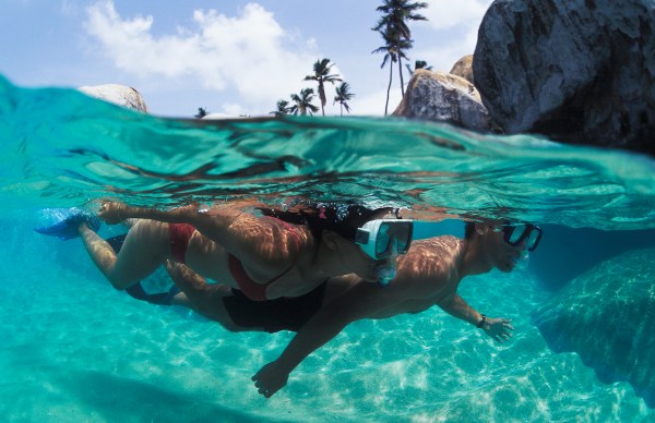 Snorkelers explore the pristine tropical waters off The Baths