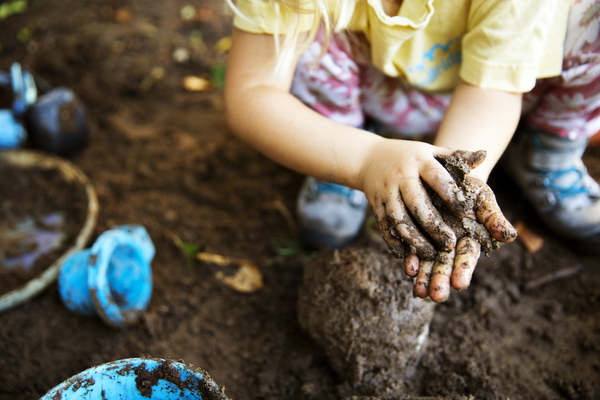 High angle view of girl playing with mud