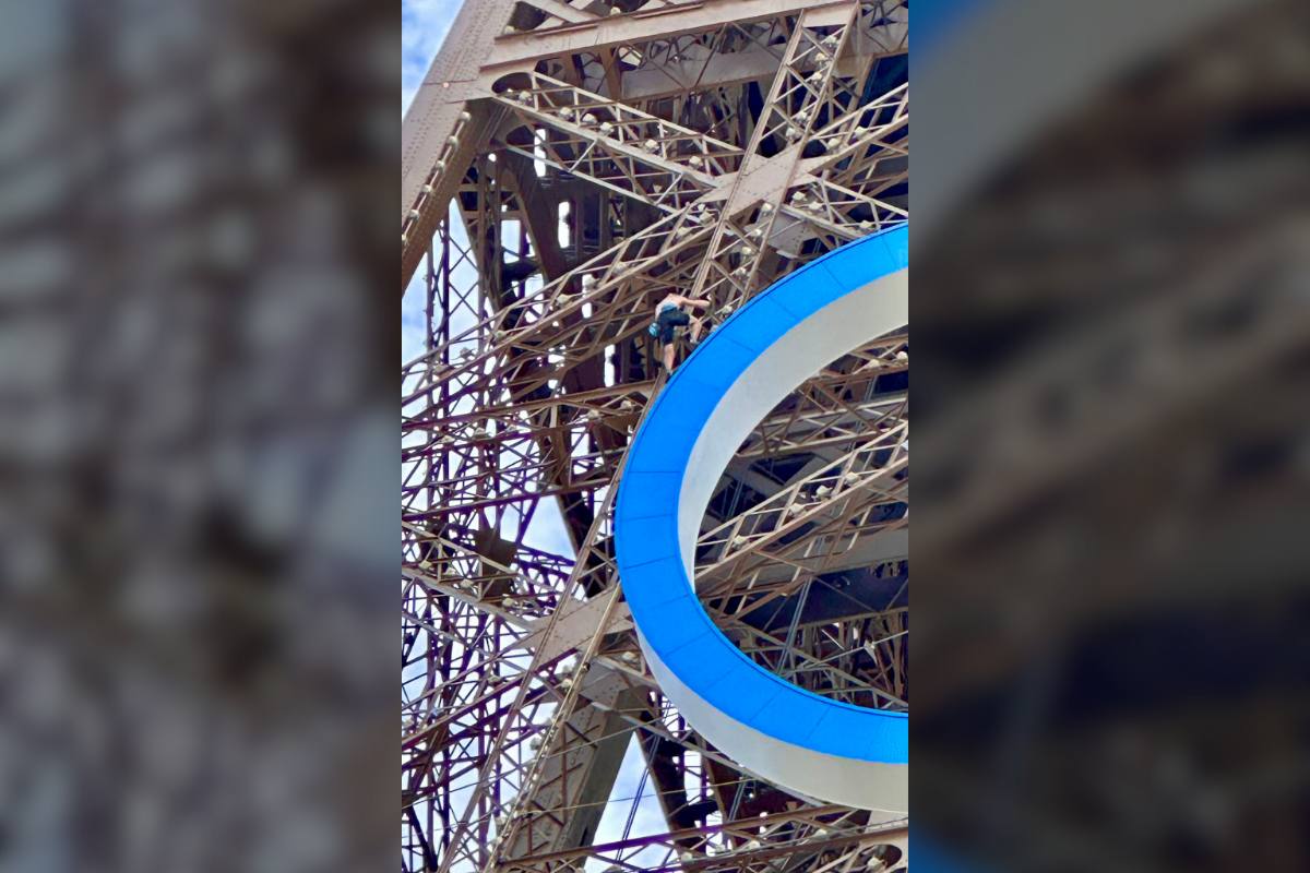 guy climbing eiffel tower